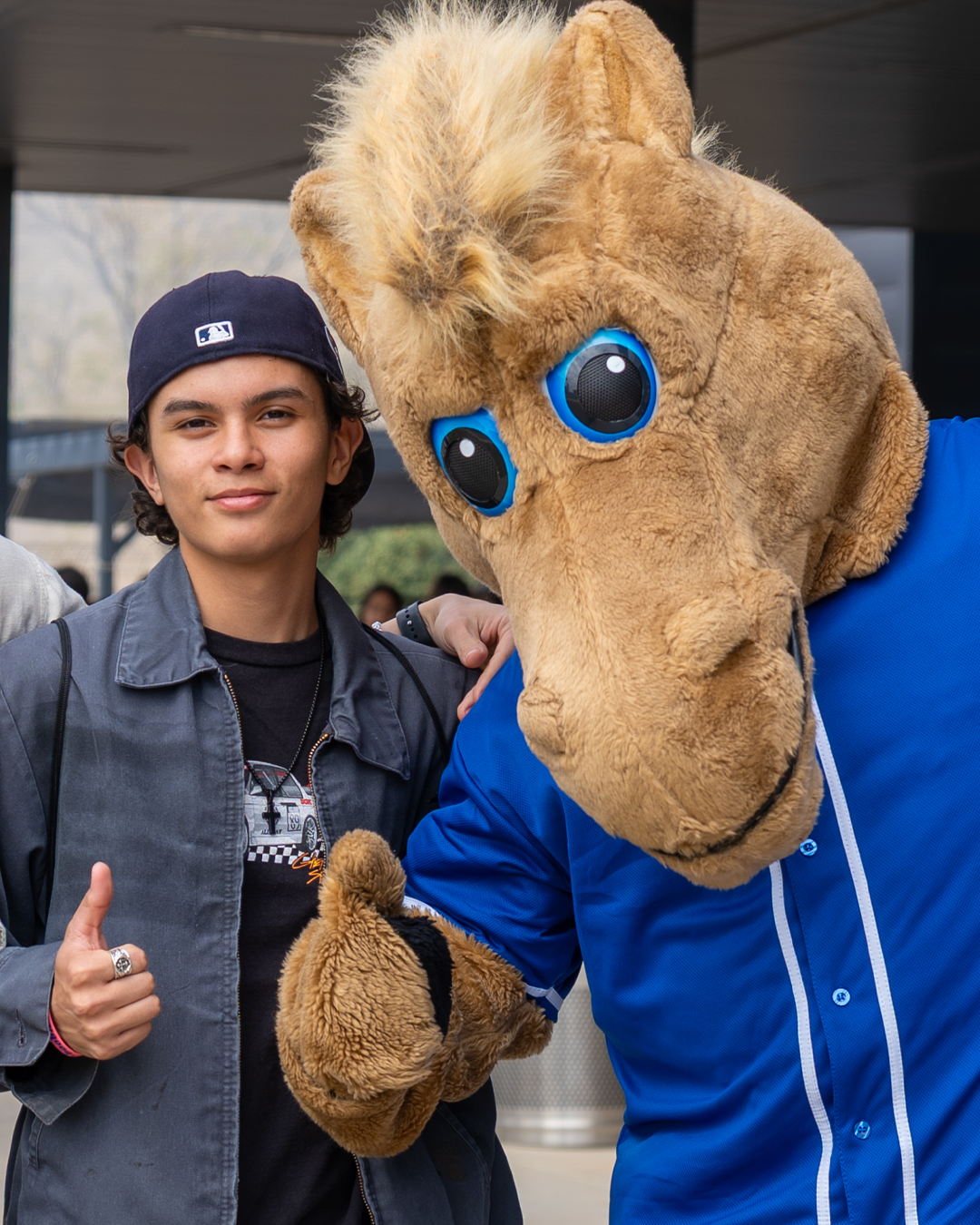 A male student and the OC horse mascot (Billie) giving thumbs up to the camera
