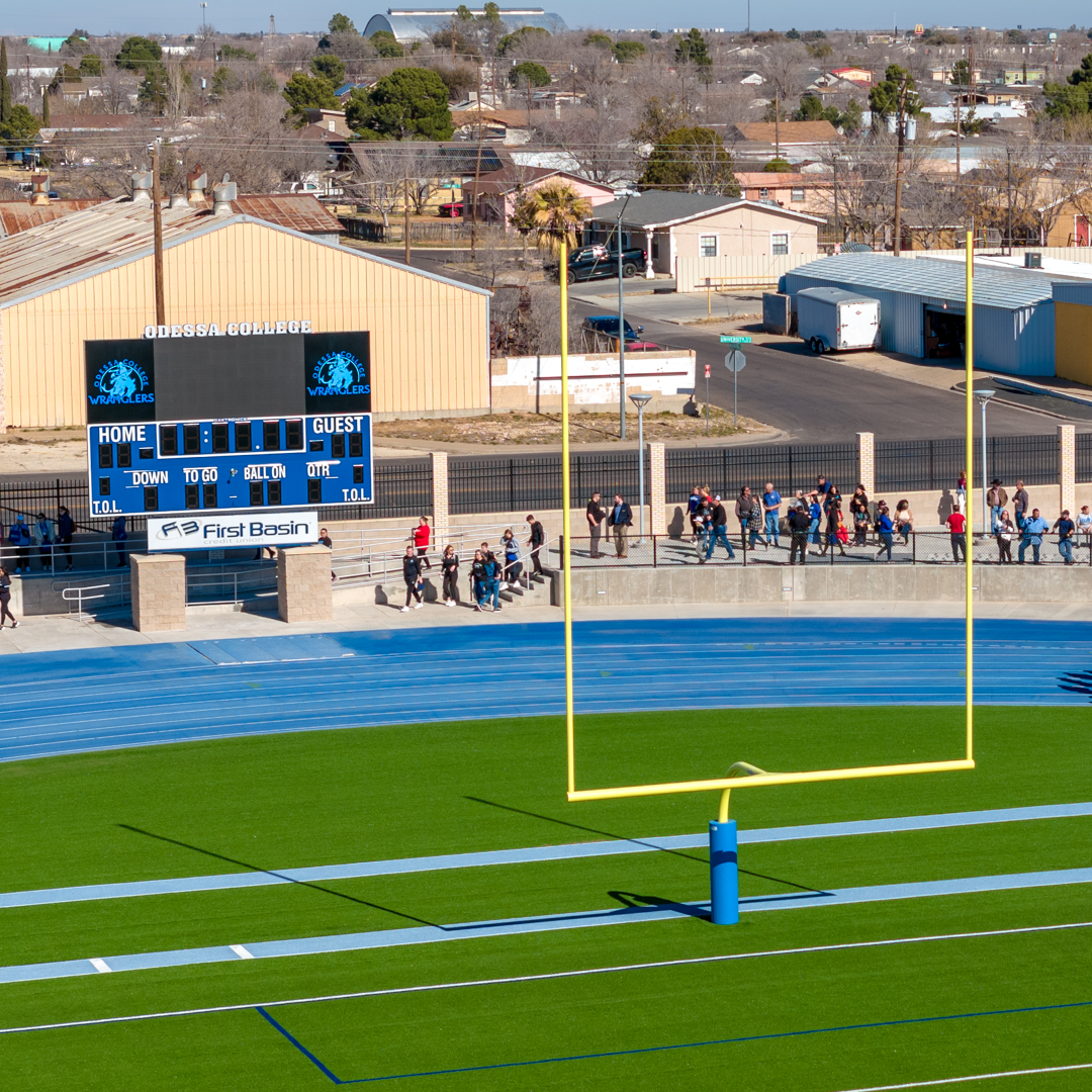 Stadium football field, blue track, and score board