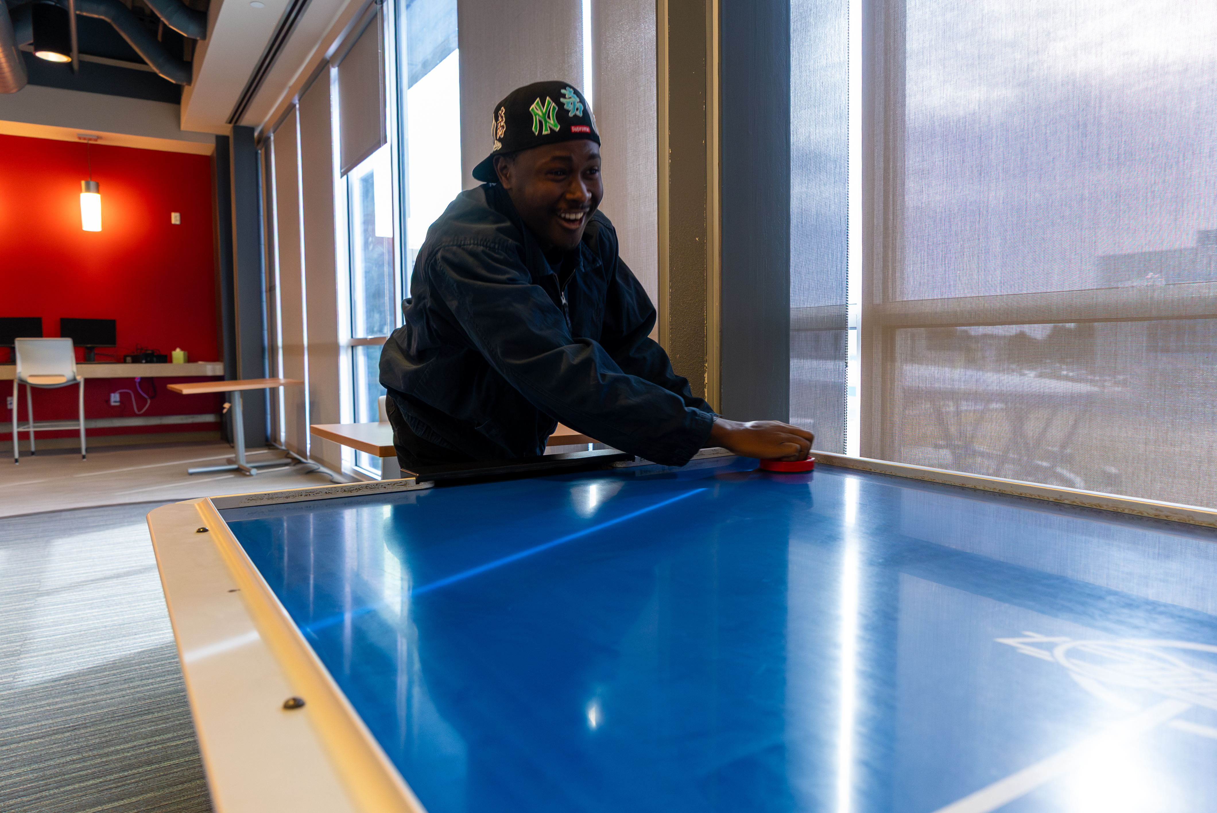 Student having a great time playing air hockey in the game room.