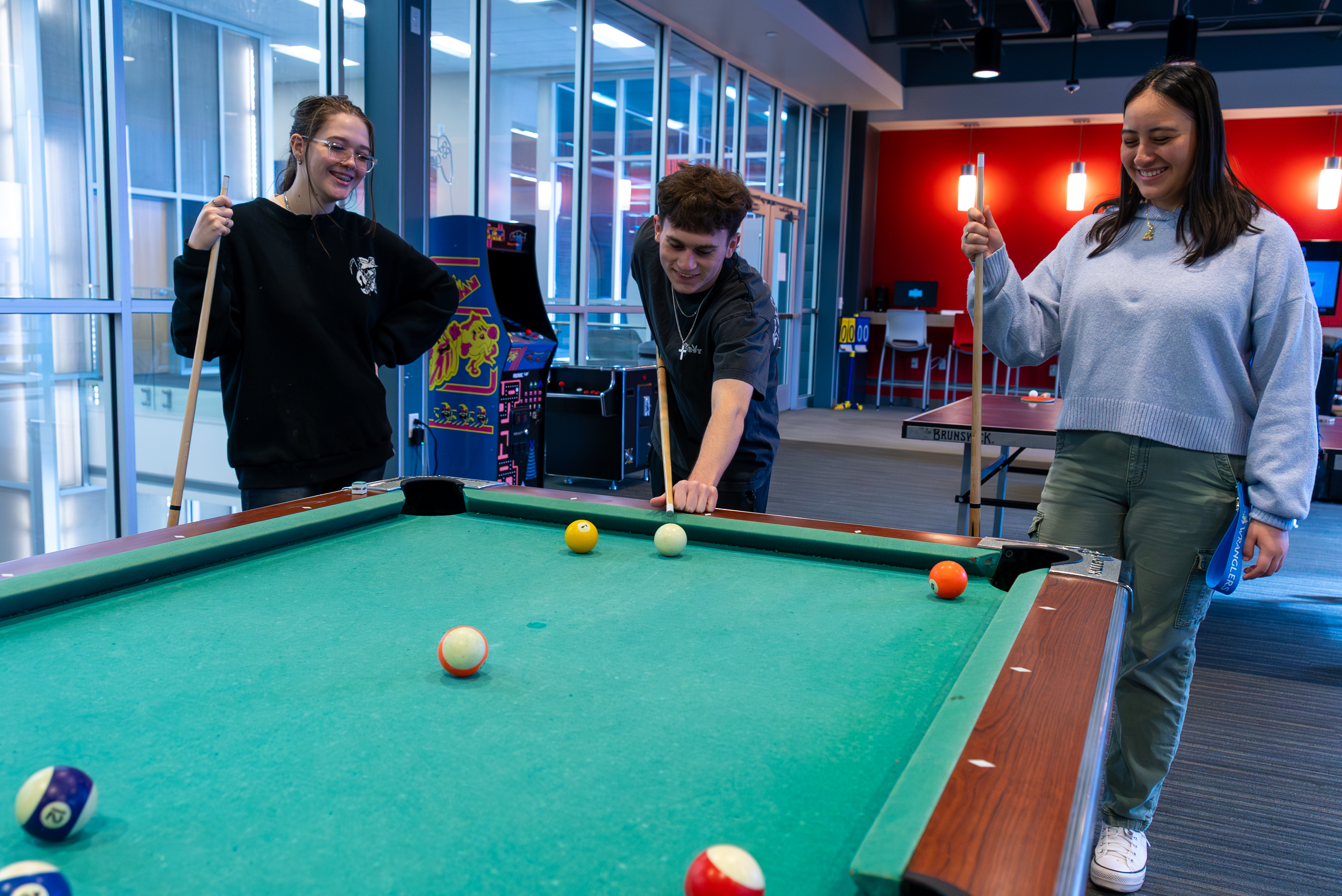 Students having fun playing pool together.