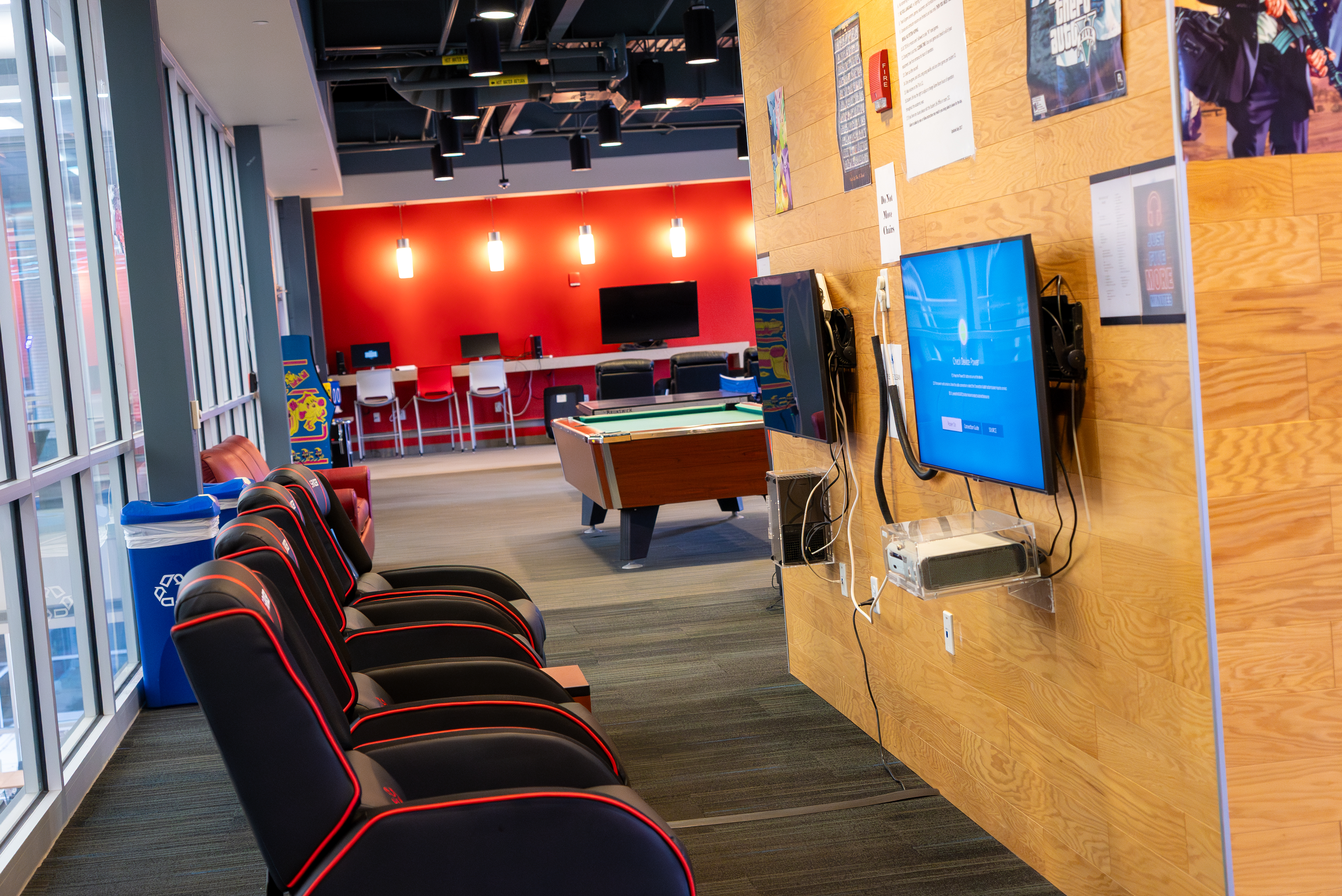 A shot of the empty game room with video game stations and pool tables.