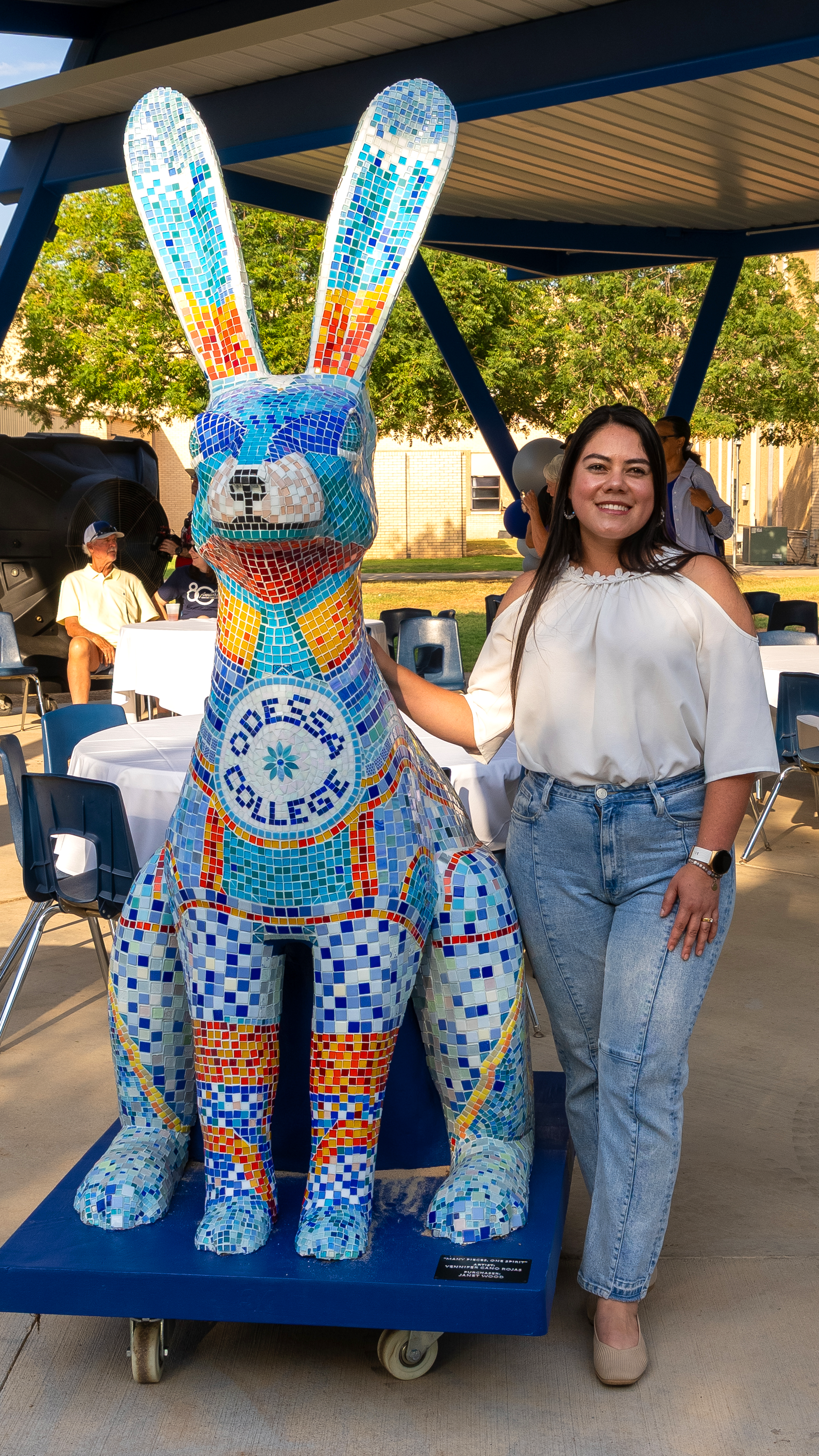Yennifer Cano Rojas smiling and standing next to the mosaic jackrabbit statue
