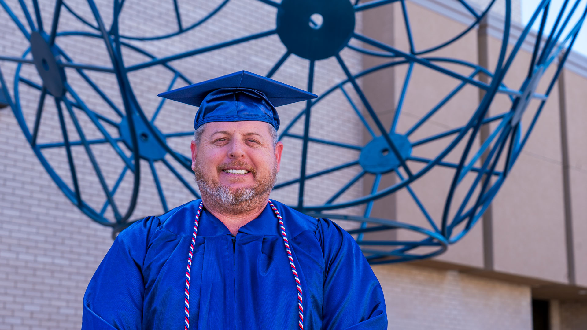 Chris Waters smiling with a blue statue behind him