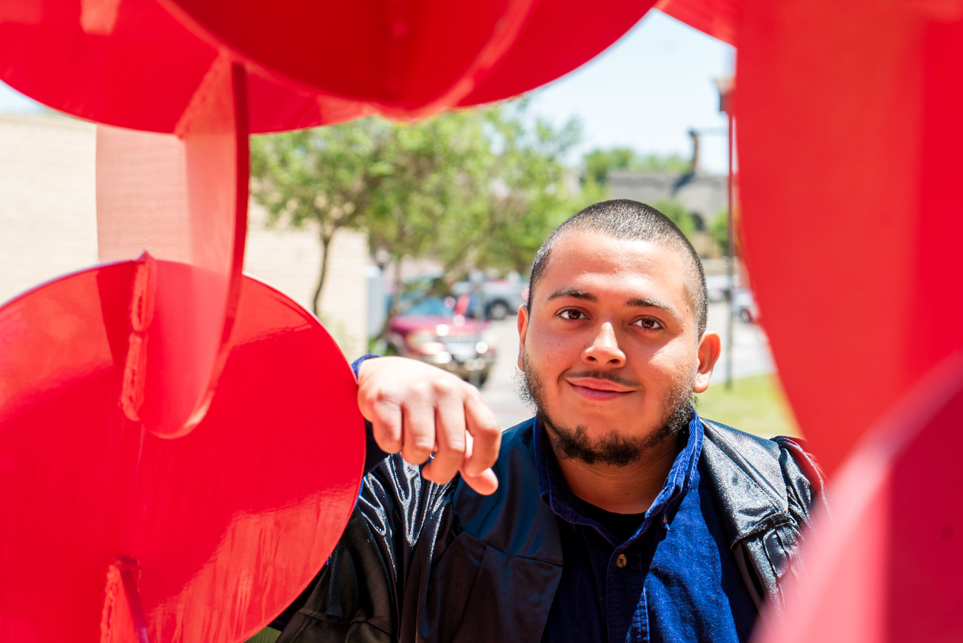 Jonathan smiling with a red sculpture