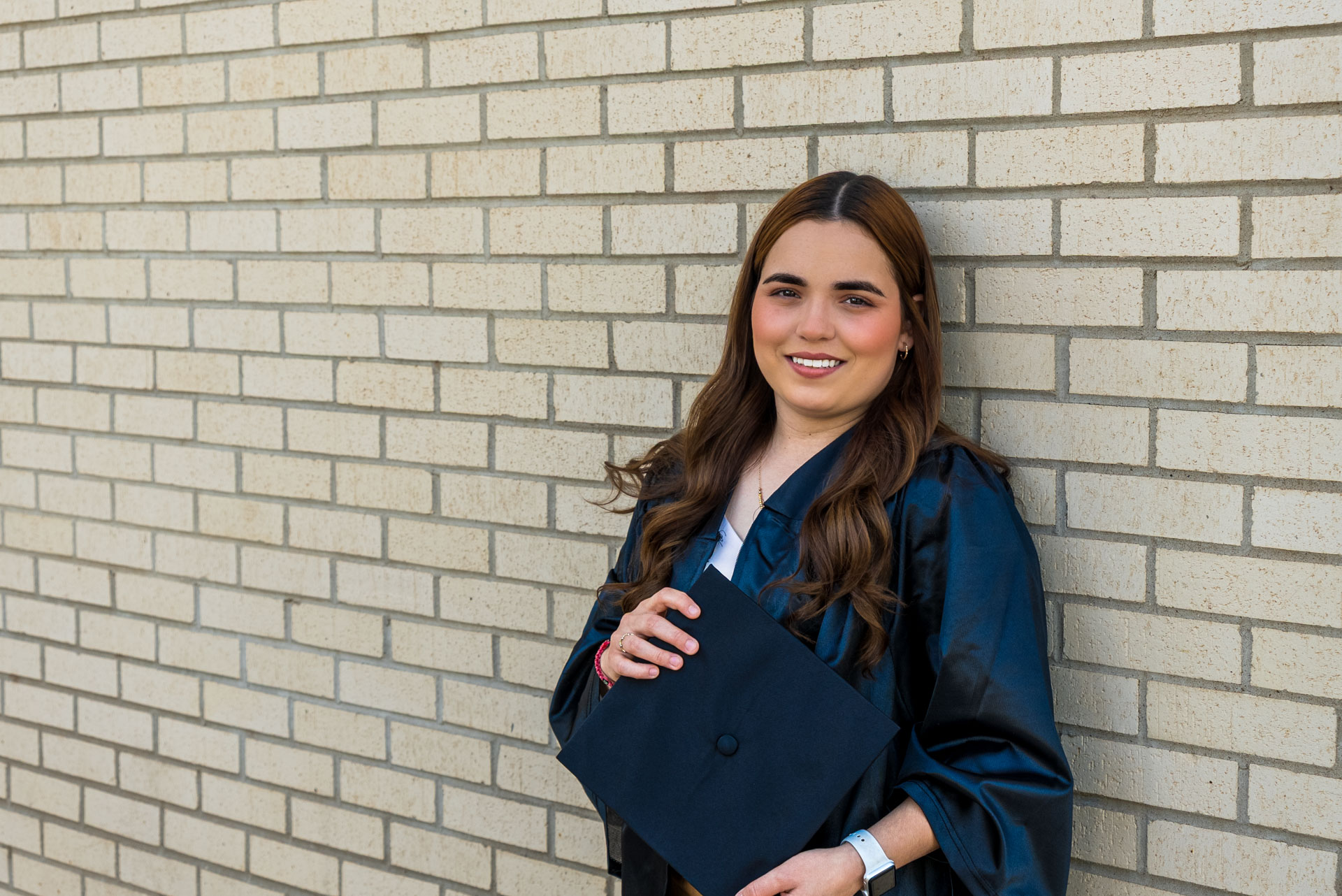 Gissell Fabela leaning against a brick wall