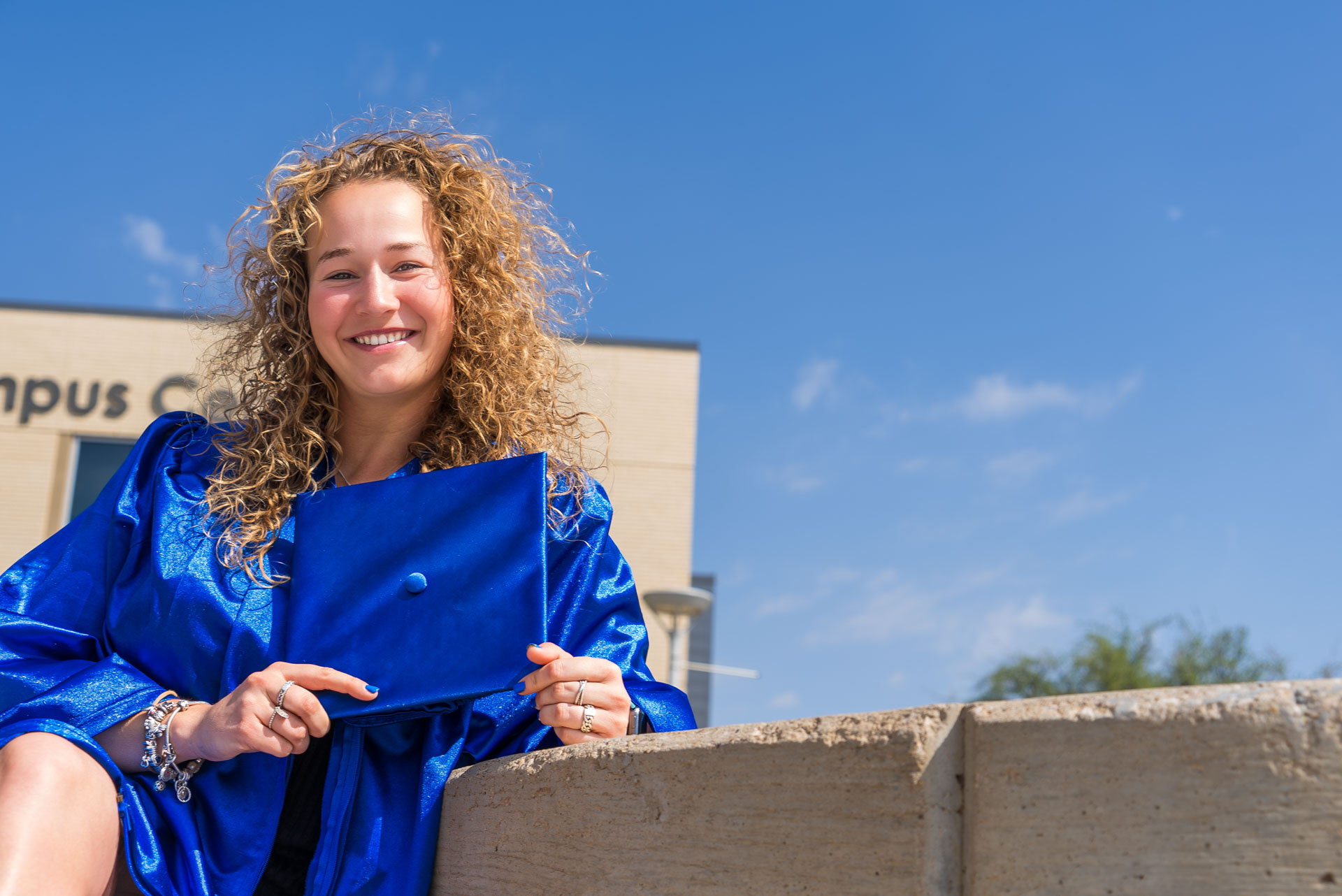 Rens Tellekamp sitting and holding grad cap